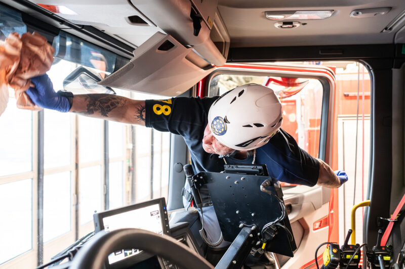 Roger tvättar insidan på fönsterrutan av en brandbil