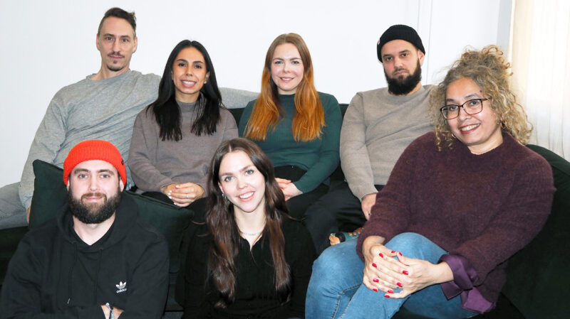 Personal om 8 personer som sitter i en soffa,