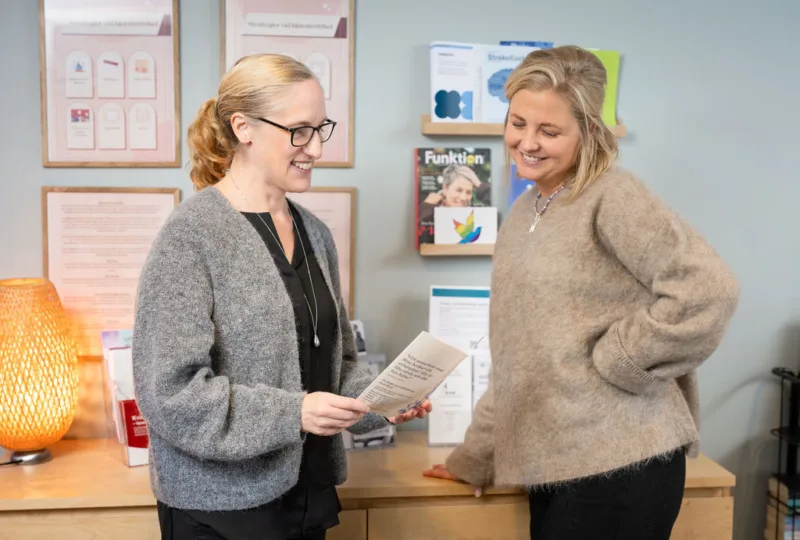 En arbetskonsulent och deltagare tittar i en folder tillsammans