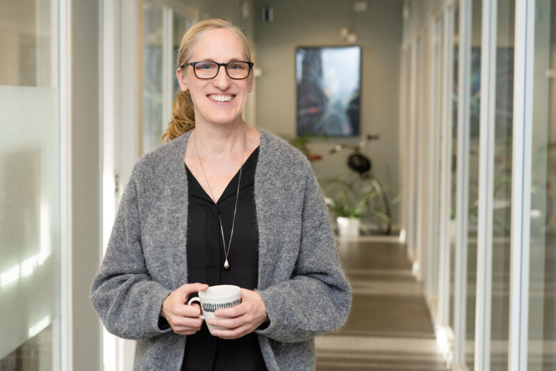 Kvinna i korridor med en kaffekopp