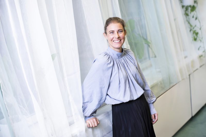 En kvinna står framför ett fönster