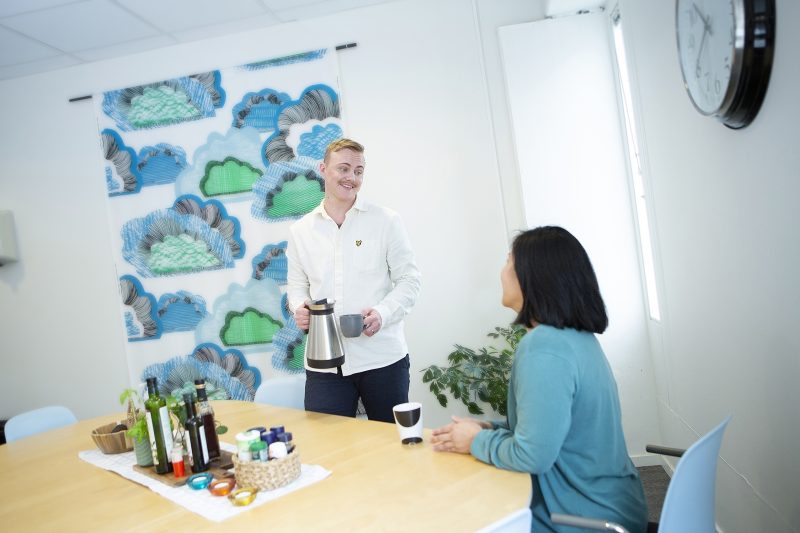 En person häller upp kaffe till en annan personal