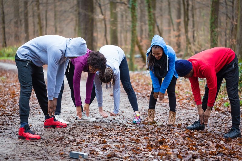 fem ungdomar i skogen som stretchar