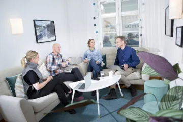 Fyra personer sitter i soffa och samtalar